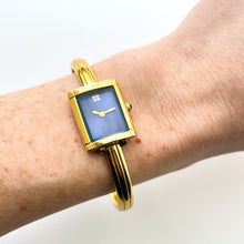Load image into Gallery viewer, Vintage 90s Yves Saint Laurent Ladies' Bangle Style Quartz Watch with Gold-Tone Bracelet and Metallic Blue Dial